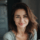 Portrait d'une femme souriante aux cheveux bruns.